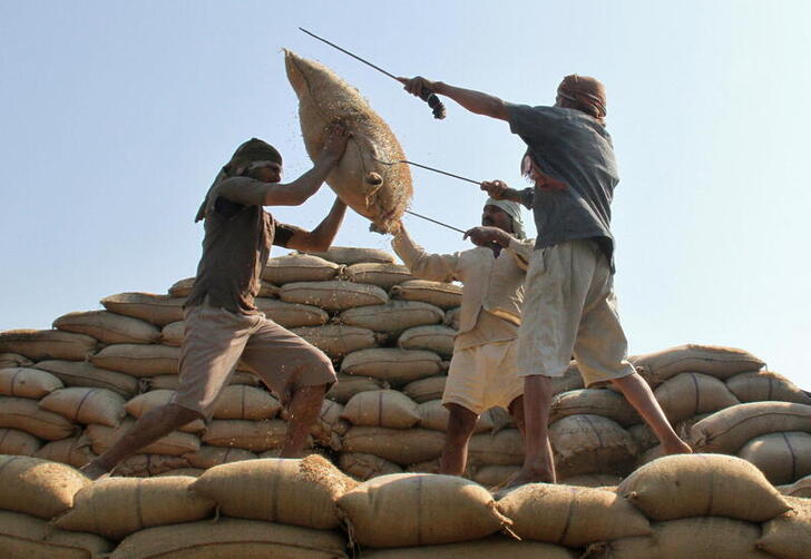 FILE PHOTO: Workers lift a sack of rice to load onto a truck at a wholesale grain market in the northern Indian city of Chandigarh February 9, 2012. REUTERS/Ajay Verma/File Photo