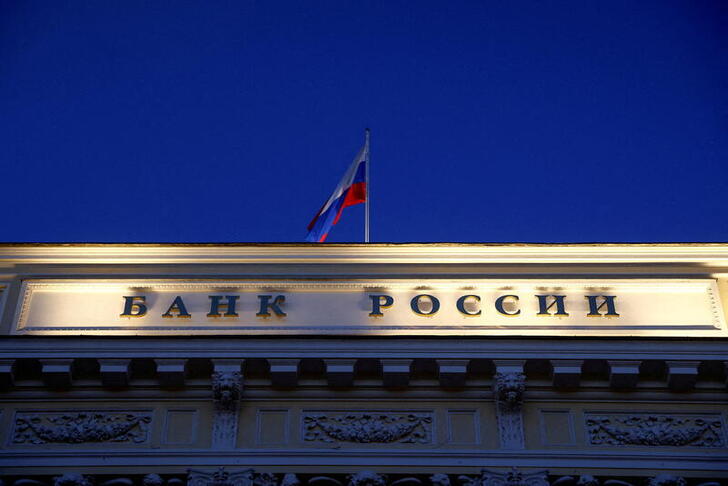 FILE PHOTO: A Russian state flag flies over the Central Bank headquarters in Moscow, Russia March 29, 2021. A sign reads: 