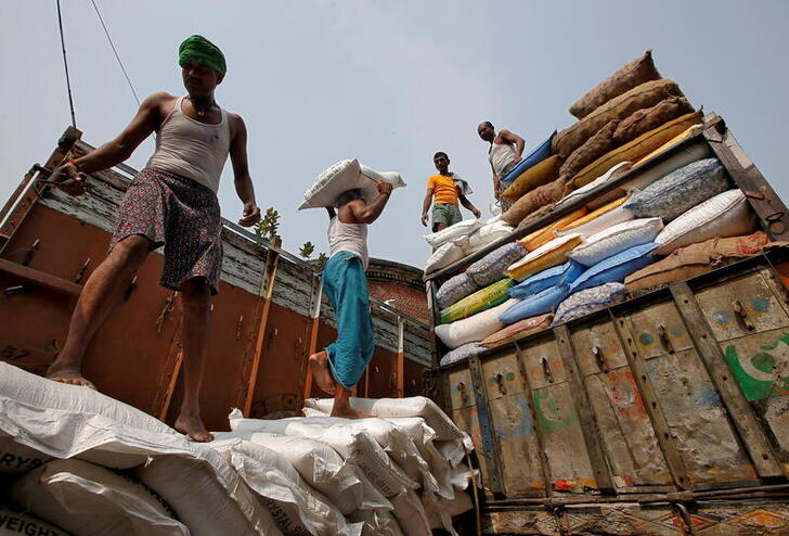 FILE PHOTO: A labourer carries a sack filled with sugar to load it onto a supply truck at a wholesale market in Kolkata, India, November 14, 2018. REUTERS/Rupak De Chowdhuri/File Photo/File Photo