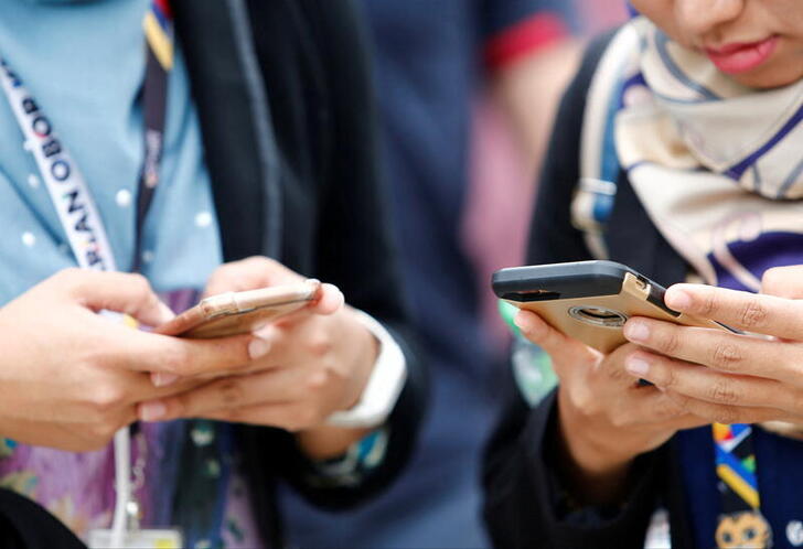 FILE PHOTO: People use their mobile phones at a university in Semenyih, outside Kuala Lumpur, Malaysia November 3, 2017. REUTERS/Lai Seng Sin/File Photo