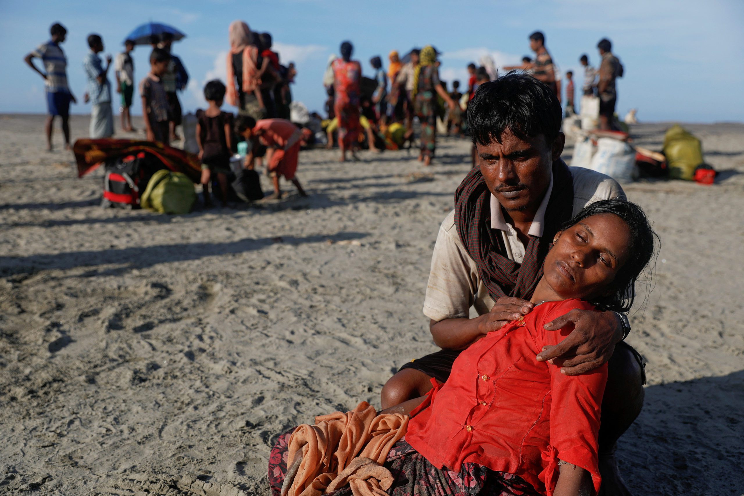 Arif Ullah, who said his village was burnt down and relatives killed by Myanmar soldiers, comforts his wife Shakira, who collapsed from exhaustion as fleeing Rohingya refugees crossed into Bangladesh on a wooden boat in 2017. REUTERS/Damir Sagolj