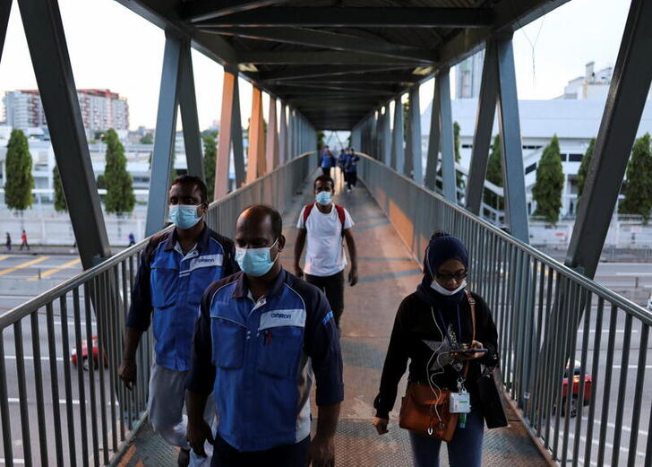Migrant workers walk back to their home from work at an electrical and electronics industrial zone of Sungei Way Free Trade Zone in Petaling Jaya, Selangor, Malaysia, June 10, 2022. Picture taken June 10, 2022. REUTERS/Hasnoor Hussain