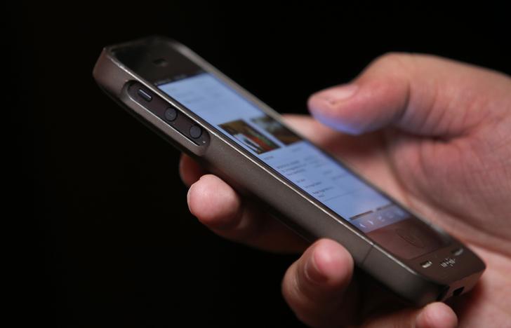 A man uses a smartphone in New York City, in this picture taken November 6, 2013.  Twitter Inc raised the top end of its IPO price range by 25 percent and will close its books a day early, signaling strong demand for the most closely watched Silicon Valley debut since Facebook Inc last year. REUTERS/Mike Segar     (UNITED STATES - Tags: SCIENCE TECHNOLOGY BUSINESS TELECOMS)