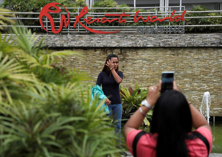 Visitors take picture with the signage of Genting Malaysia?s Resorts World which is displayed at its complex of casino, hotel and entertainment park in Genting Highlands, Pahang, Malaysia September 16, 2022. REUTERS/Hasnoor Hussain
