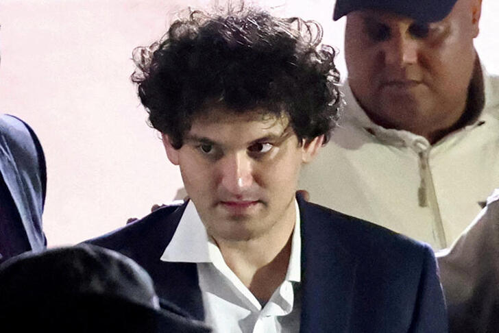 FILE PHOTO: FILE PHOTO: Sam Bankman-Fried, who founded and led FTX until a liquidity crunch forced the cryptocurrency exchange to declare bankruptcy, is escorted out of the Magistrate Court building after his arrest in Nassau, Bahamas December 13, 2022.  REUTERS/Dante Carrer/File Photo/File Photo
