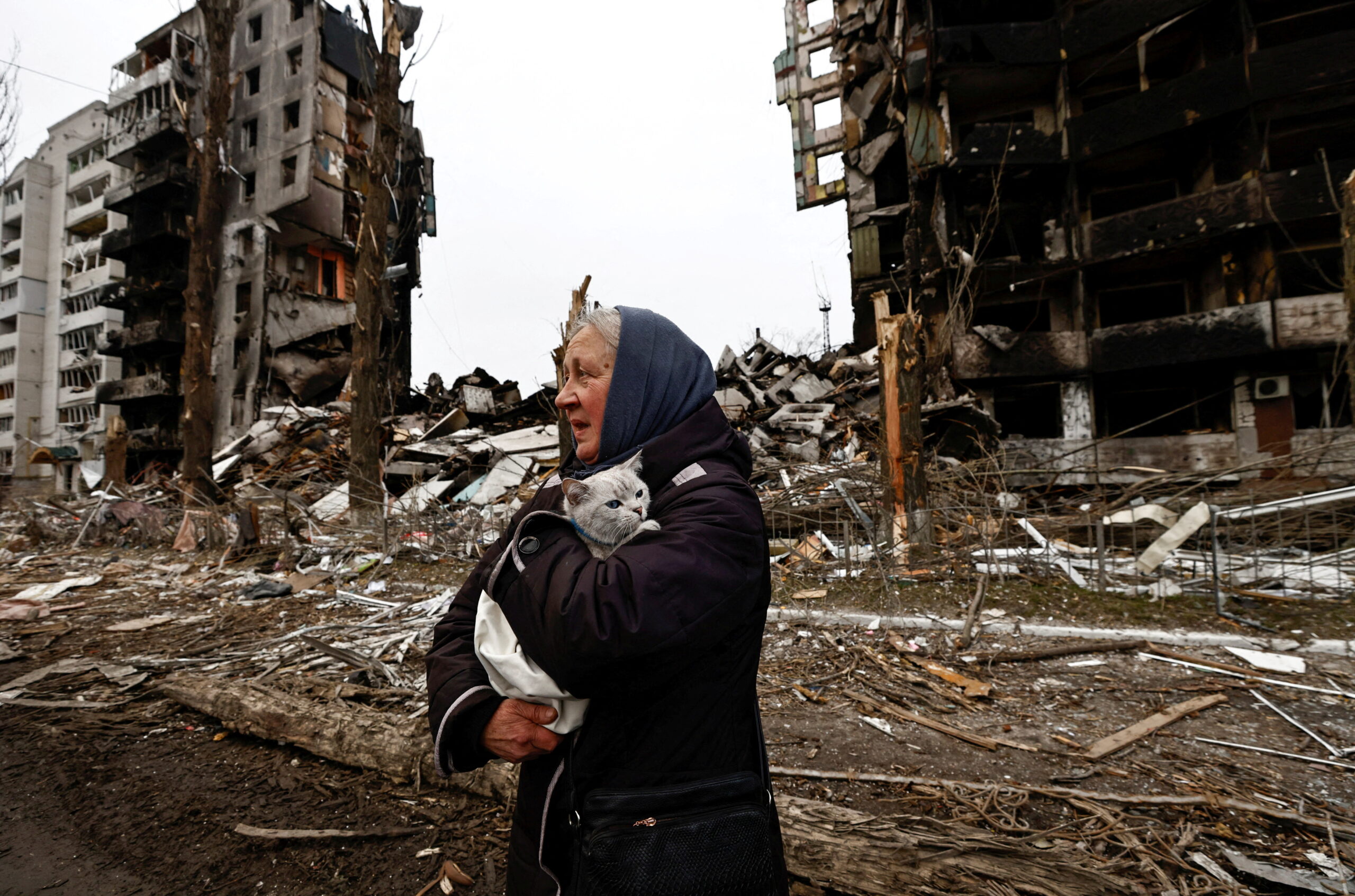 A woman carries her cat as she walks past buildings that were destroyed by Russian shelling, amid Russia's invasion of Ukraine in Borodyanka, in the Kyiv region, Ukraine, April 5, 2022.        REUTERS/Zohra Bensemra