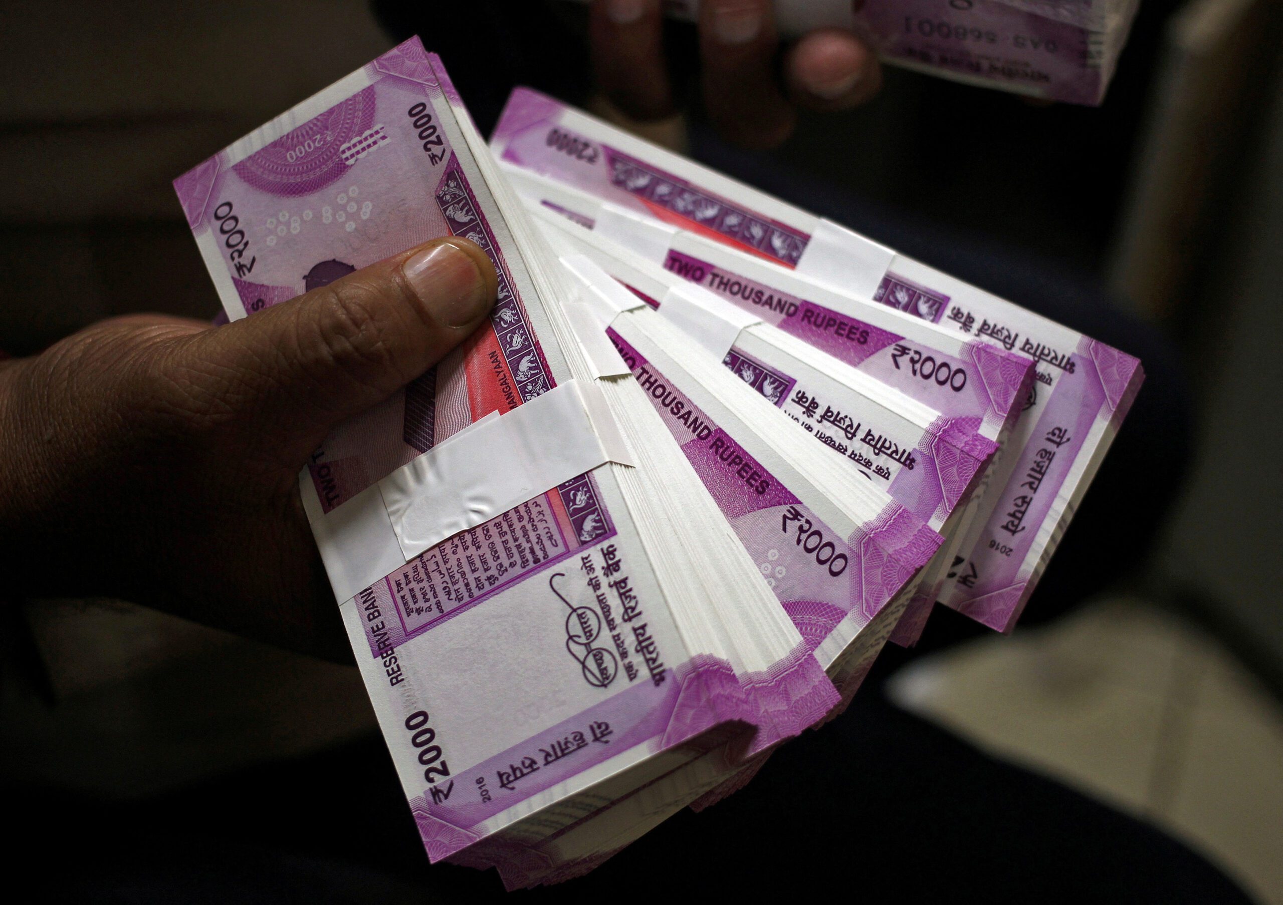 FILE PHOTO: FILE PHOTO: A cashier displays the new 2000 Indian rupee banknotes inside a bank in Jammu, November 15, 2016. REUTERS/Mukesh Gupta/File photo/File Photo