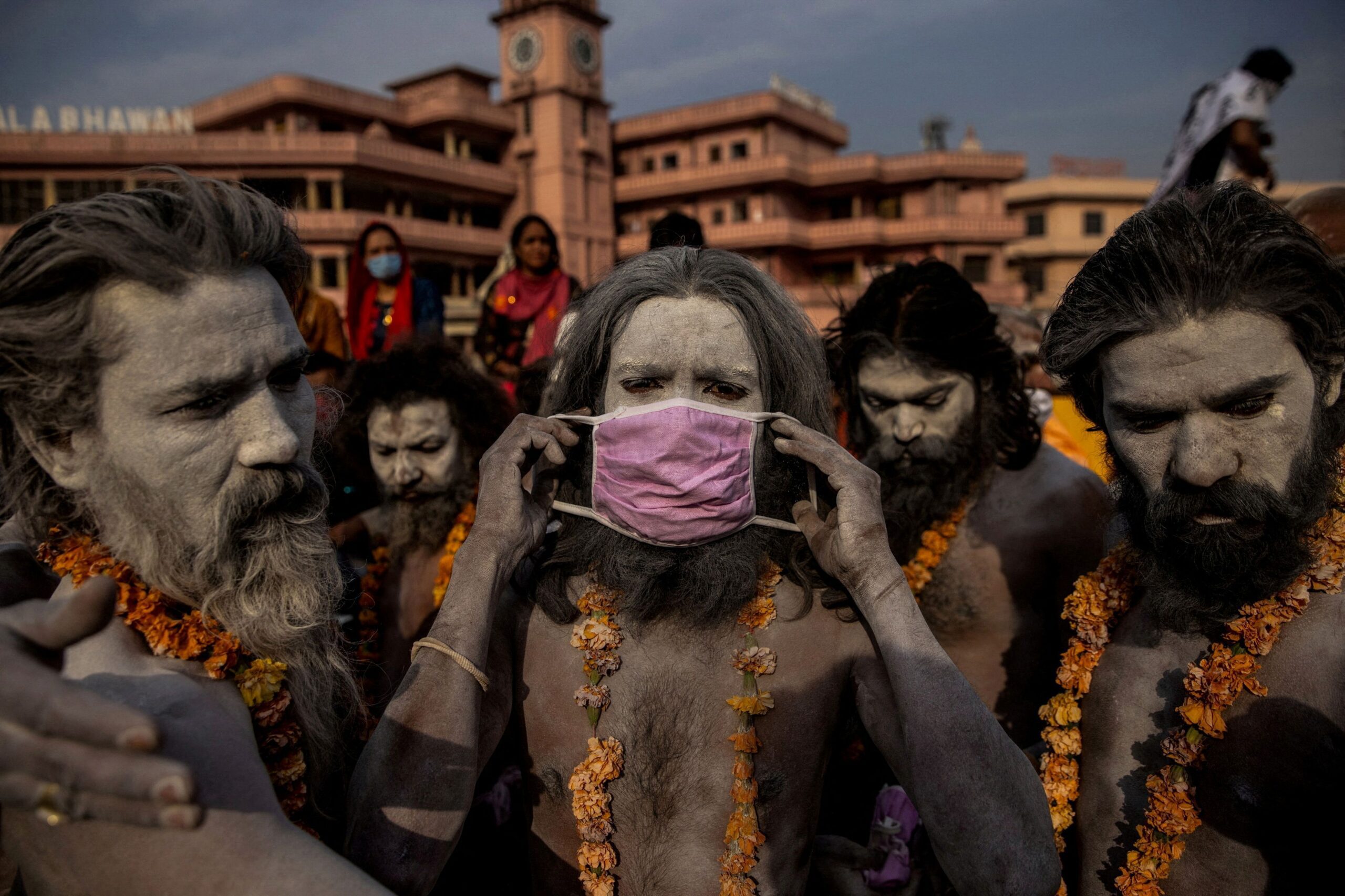 A 'Naga Sadhu,' or Hindu holy man, places a mask across his face before entering the Ganges river during the traditional Shahi Snan, or royal dip, at the Kumbh Mela festival in Haridwar, India, April 12, 2021. As coronavirus disease (COVID-19) cases and deaths exploded in India in April and May, hospitals ran so short of oxygen that many patients suffocated. REUTERS/Danish Siddiqui