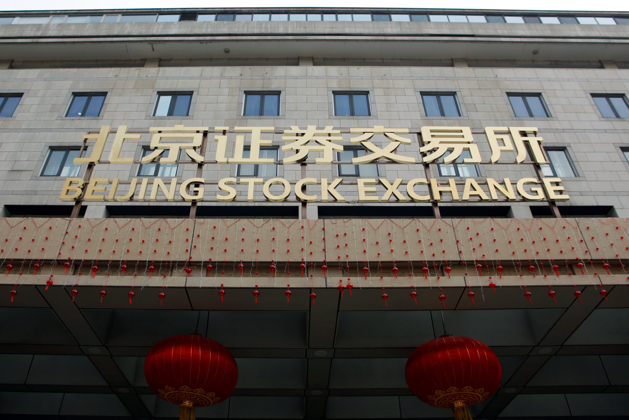 The sign of Beijing Stock Exchange is seen at its entrance during an organised media tour, in Beijing, China February 17, 2022. REUTERS/Florence Lo/File Photo