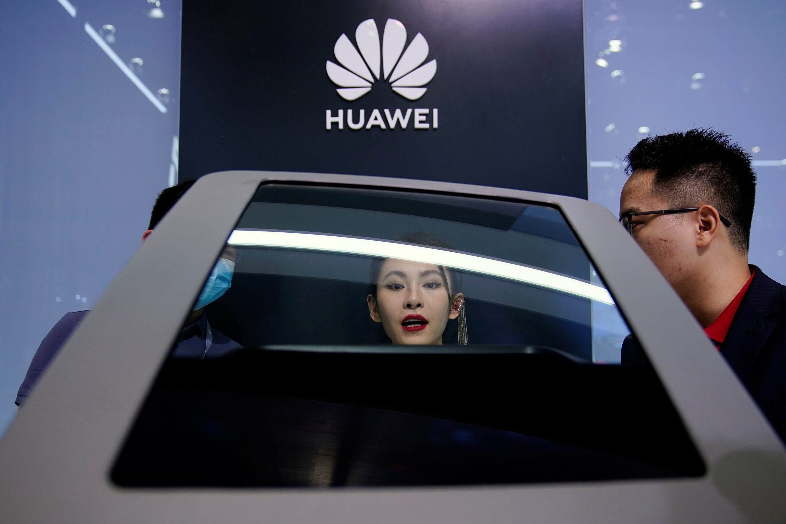 People check a display near a Huawei logo during a media day for the Auto Shanghai show in Shanghai, China April 19, 2021. REUTERS/Aly Song