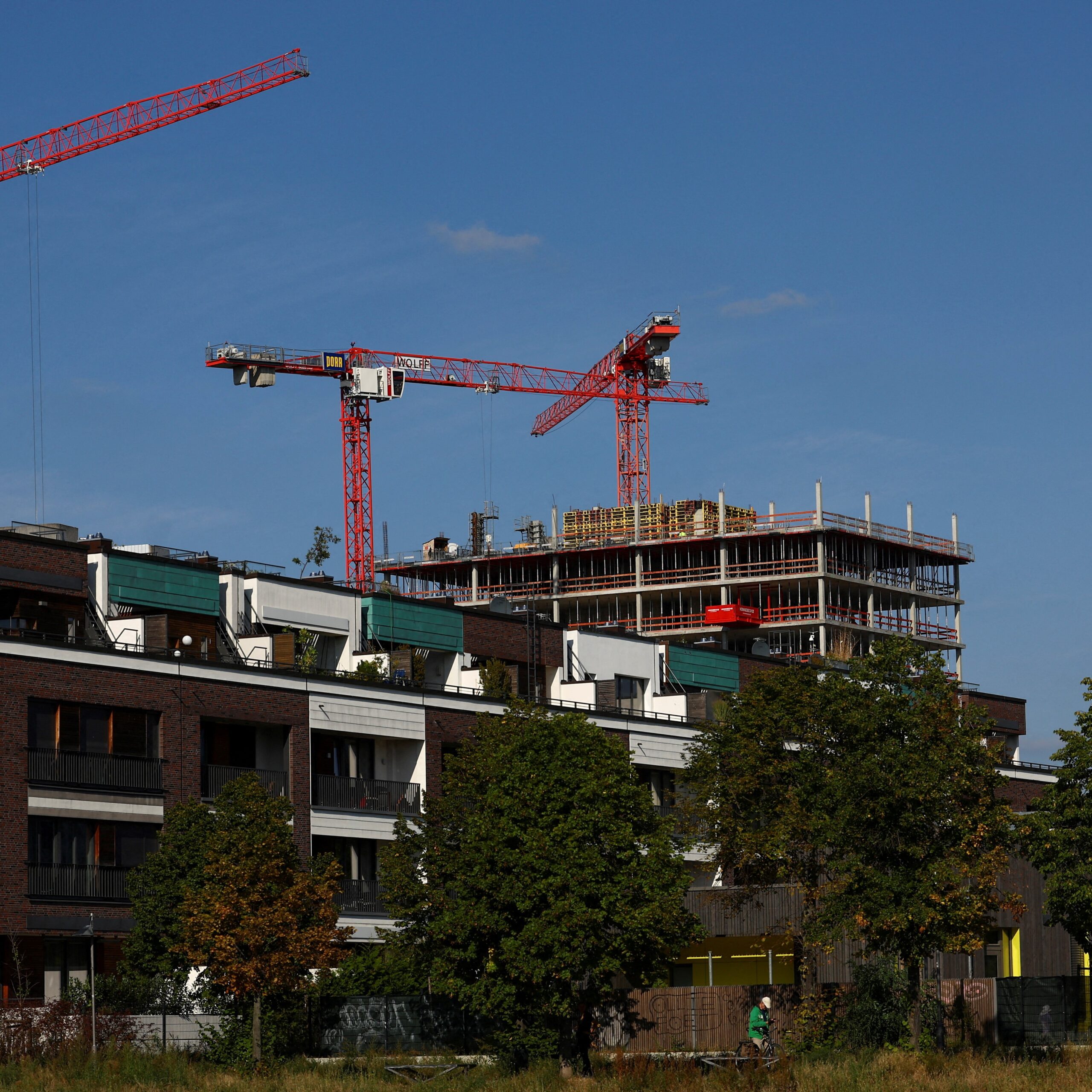FILE PHOTO: Cranes of a construction site are seen near a residential building, ahead of the summit for affordable housing and construction at the Chancellery in Berlin, Germany September 25, 2023. REUTERS/Lisi Niesner/File Photo
