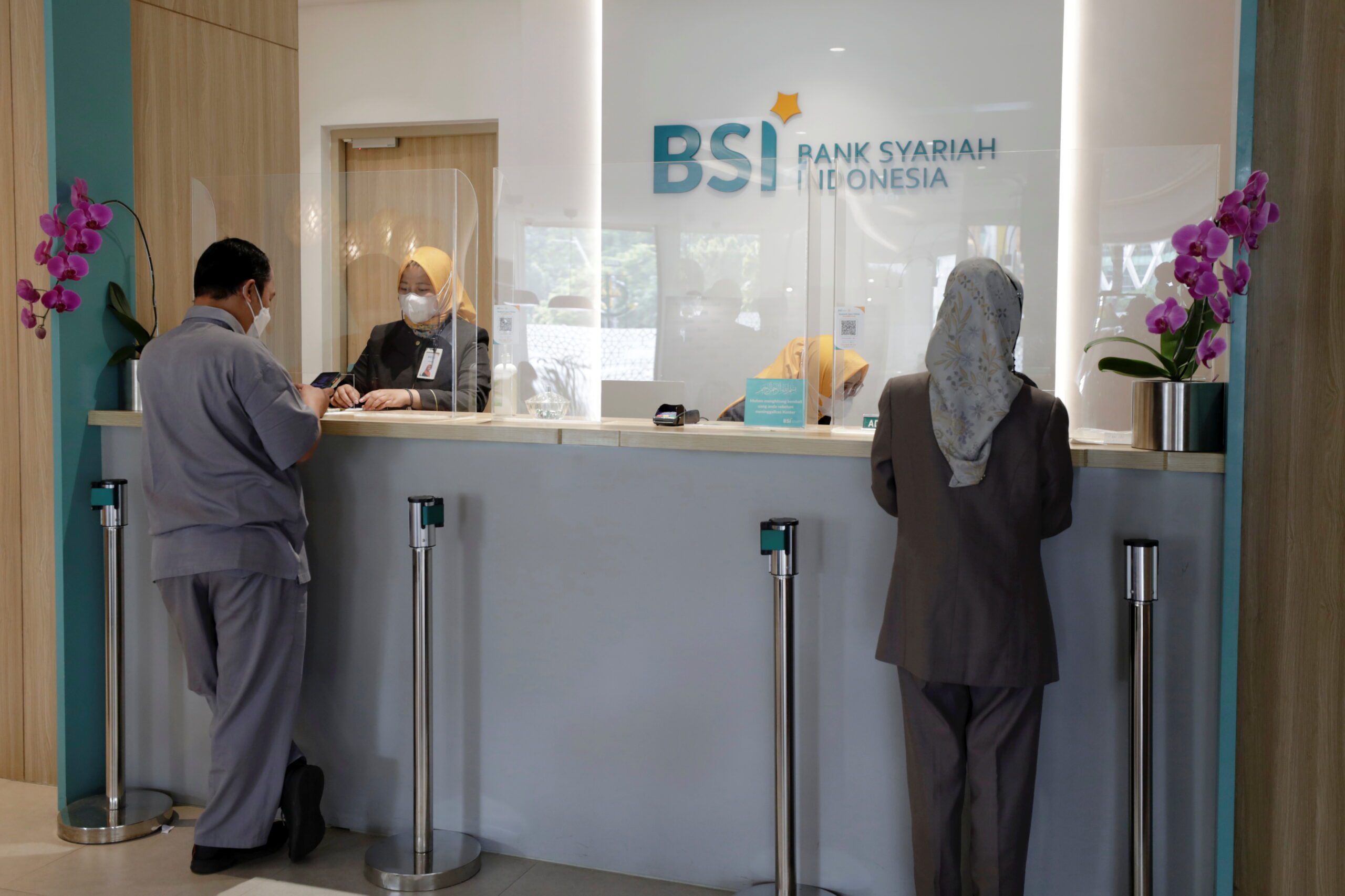 Bank tellers serve customers at Bank Syariah Indonesia in Jakarta, Indonesia, June 8, 2021. REUTERS/Willy Kurniawan