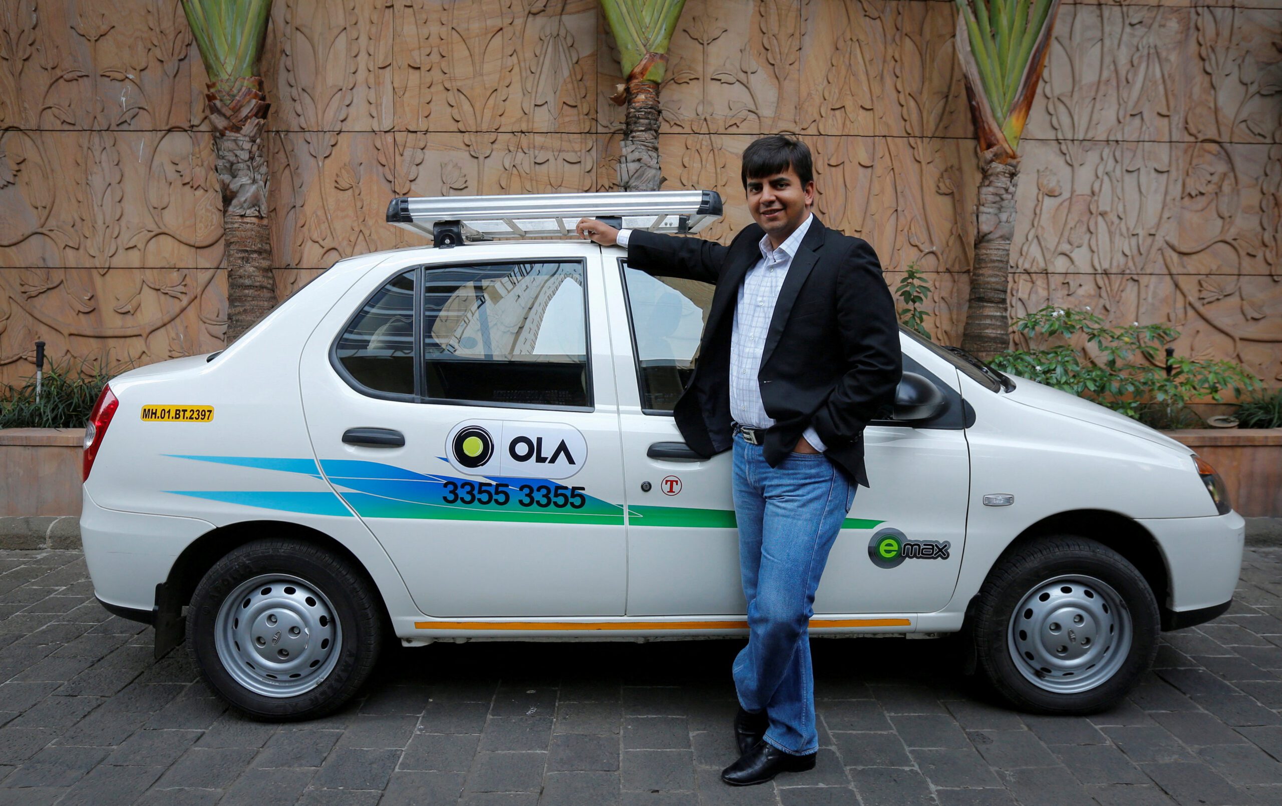 FILE PHOTO: Bhavish Aggarwal, CEO and co-founder of Ola, an app-based cab service provider, poses in front of an Ola cab in Mumbai March 3, 2015. REUTERS/Shailesh Andrade/File Photo